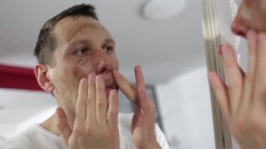 close up video how a man is applying a man massaging coffee scrub on his face. man is doing at home skin routine. body and face care. beauty concept. spa and wellness.