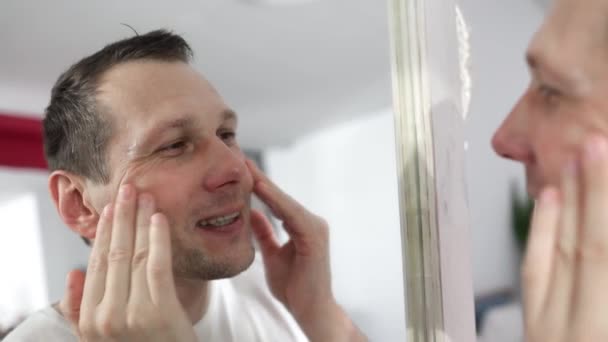 Caucasian Man Touching Face Applying Moisturizer Face Standing Mirror Modern — Stok Video