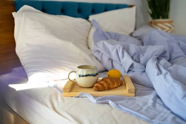 breakfast, cozy, morning, cozy bedroom with cup of coffee and croissant on wooden board in bed at home