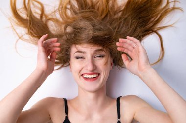 Expressive portrait of a beautiful young blonde woman in the studio on a white background, the concept of beauty.