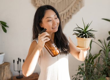 Asian girl Water the plants in house, she is holding cactus, Water the plants, fertilizer and house plants concept.