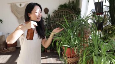 Asian Woman hand spray on leave plants in the morning at home using a spray bottle watering houseplants Plant care concept