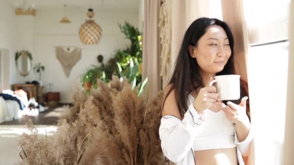 Asian Middle Aged Woman Drinking Tea Coffee While She Looking — Stockvideo