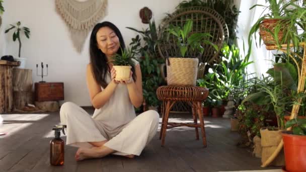 Smiling Asian Woman Holding Watering Cactus Plant Home — стокове відео