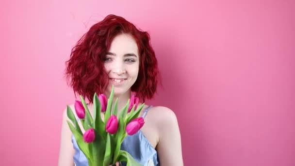 Krásná Dívka Krátkými Kudrnaté Vlasy Květiny Tulipány Rukou Růžovém Pozadí — Stock video