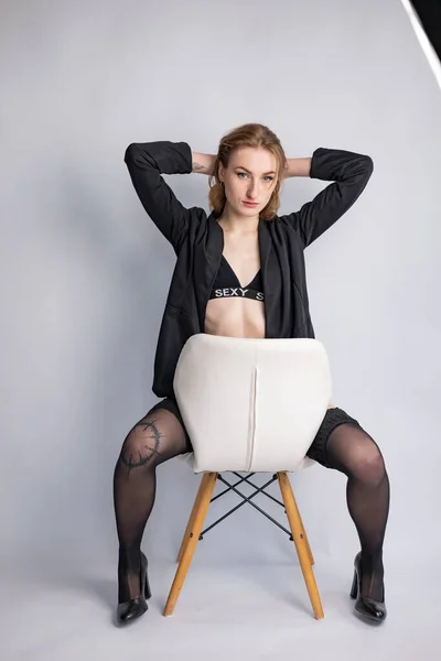 Fashion model in black jacket and black panties. Beautiful happy woman with sexy body. Blonde long brown hair and natural makeup. Stylish fashion model. Sensual woman dressed in black.