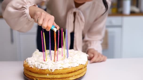 快乐的亚洲女人在生日蛋糕上点着蜡烛 有选择地关注蛋糕和面容 — 图库视频影像