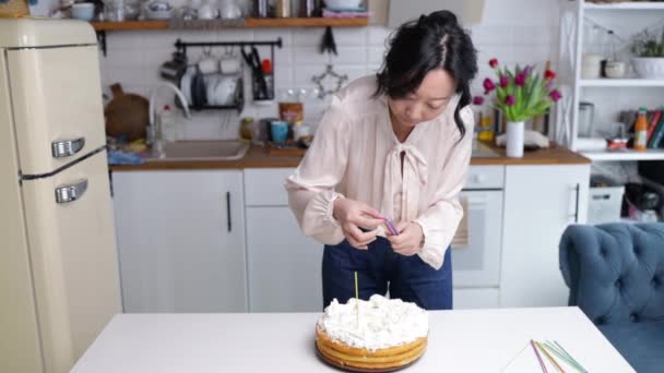 蛋糕蜡烛的烹调和装饰 女孩手伸进厨房装饰白色奶油蛋糕 厨房里的年轻女人做漂亮的生日蛋糕 — 图库视频影像