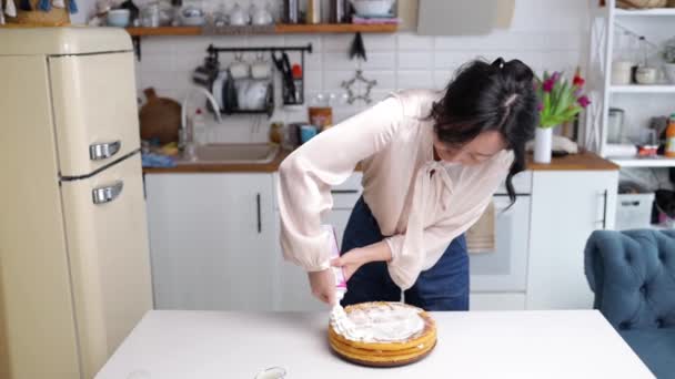 아시아 케이크에 채찍질을 과자를 여자가 스펀지 케이크에 크림을 있습니다 집에서 — 비디오