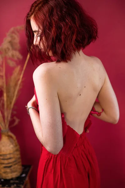 nice lady with beautiful back covered by red silk on red background