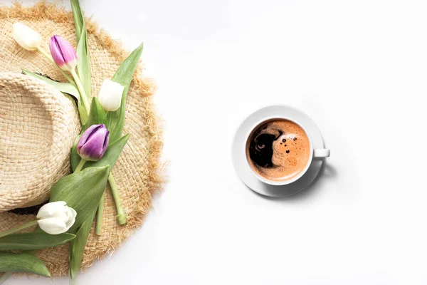 Spring background with flowers, a cup of coffee and pink tulips on a sun hat. good morning on March 8 or Mother\'s Day with a place for text. Copy space.