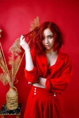 Kırmızı elbiseli şık bir genç bayan. Kırmızı arkaplan.