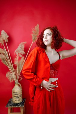 Kırmızı elbiseli şık bir genç bayan. Kırmızı arkaplan.