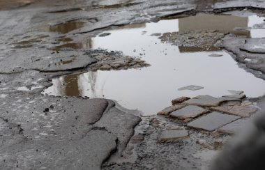 Eski ıslak asfalt parçası ve yağmurdan sonra bir taş oluğunun parçası..