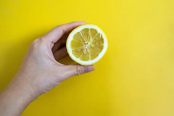 Tangan Memegang Potongan Lemon Segar Pada Latar Belakang Kuning — Stok Foto