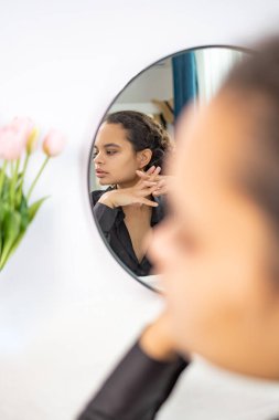 Güzellik Konsepti. Aynaya Bakan Çekici Afrikalı Kadın portresi, Milenyum güzeli, siyah ipek tişörtlü, yansıması için gülümseyen, görünüşünün tadını çıkaran kadın..