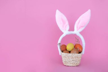 Mutlu Paskalyalar. Paskalya arkaplanını tebrik ederim. Paskalya yumurtaları ve pembe arka planda tavşan kulakları..