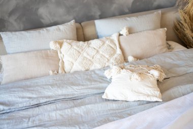 Kanepede beyaz makrome yastıklar ve örgü battaniye. İskandinav konforlu evi, detaylar iç mekan