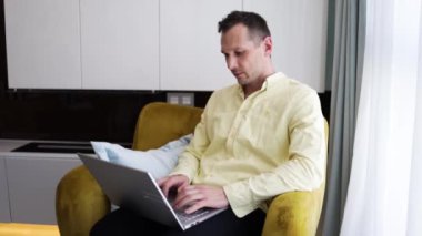 Ev ofisindeki koltuğa yaslanmış dizüstü bilgisayar kullanan serbest çalışan ciddi bir milenyum öğrencisiymiş. İşadamı dairede uzaktan not defteri üzerinde çalışıyormuş.