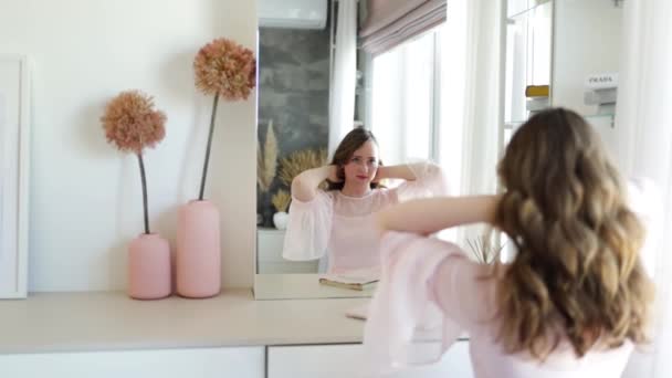 彼女の髪に触れると 鏡を見ながら笑顔の女の子 — ストック動画