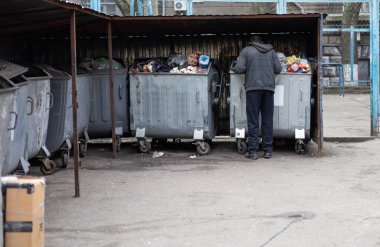 Evsiz, yaşlı bir adam çöplüğü kazıyor..