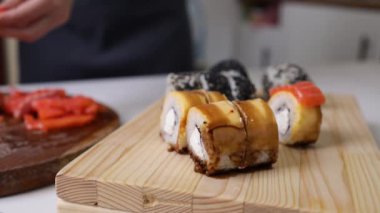 Suşi şefi suşi barında taze somon dilimler. Suşi adam Japon bıçağıyla somon bifteği kesiyor. Balıklı suşi nigiri pişiriyorum. Japon mutfağının tarifleri..