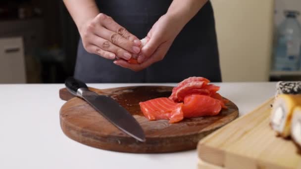 シェフの手で和食を作っています 日本人シェフがレストランで寿司を準備します 若いシェフが伝統的な日本の寿司をまな板で調理します — ストック動画