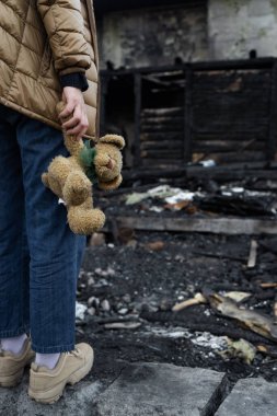 Savaş tarafından yıkılan bir evin yanındaki kız. Ukrayna 'da savaş. Ukraynalı mülteciler. Evinin harabelerindeki çocuk savaş tarafından yok edildi. Barış kavramı