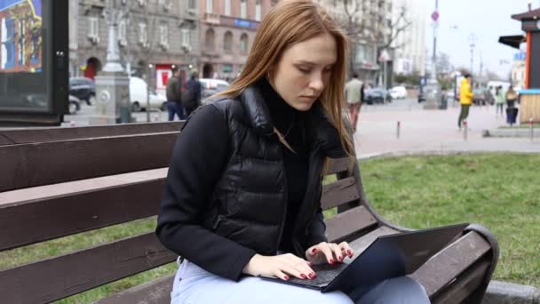 公园里使用笔记本电脑的漂亮的红头发女学生 — 图库视频影像