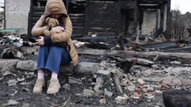 Savaş tarafından yıkılan bir evin yanındaki kız. Ukrayna 'da savaş. Ukraynalı mülteciler. Evinin harabelerindeki çocuk savaş tarafından yok edildi. Barış kavramı