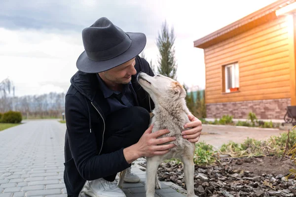 Dışarıda köpeğiyle yakışıklı genç bir adamın kırpılmış görüntüsü.. 