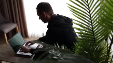 İş adamının silueti bilgisayar mesajı kullanıyor. Pencerenin yanında arkadaşça konuşmanın keyfini çıkarıyor. Dizüstü bilgisayarda yazan eller masaya otursun..