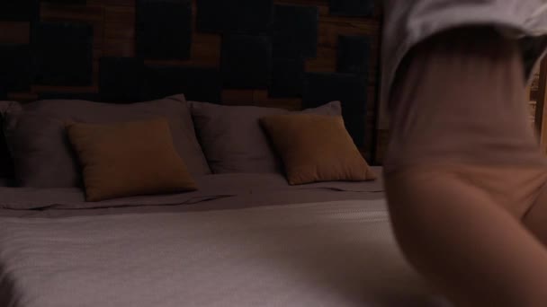 成功旅行后 快乐的年轻女子在酒店房间里享受独立的生活自由 然后跳上床休息 — 图库视频影像