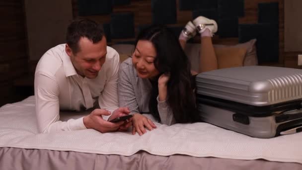 Genç Aile Reisi Gülüyor Neşeli Gülüyor Telefonuna Bak Otel Rezervasyonu — Stok video