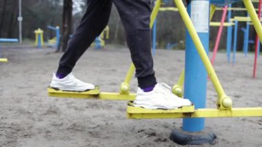 Adam bacak eğitmenine egzersiz yaptırıyor, koşuyor, yürüyor, adım atıyor. Bacaklarını kapat..