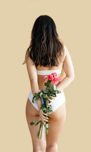 穿着白色女士内衣的性感亚洲女孩 背着米色背景的粉红玫瑰 — 图库照片