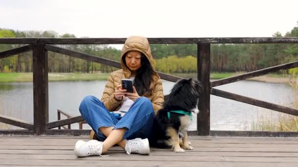 Jovem Adulto Asiático Mulher Sentado Uma Ponte Parque Olha Para — Vídeo de Stock