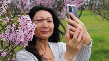 Yavaş Hareketli Asyalı Kadın Pembe Sakura Çiçekleri ile Selfie Çekiyor.