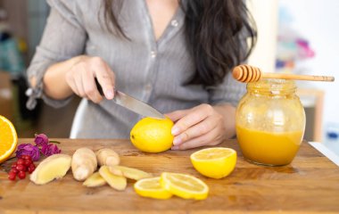 Tahta masada limon ve bal eşliğinde sağlıklı zencefil çayı yapmak.