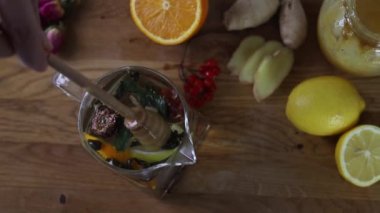 Tahta masada limon ve bal eşliğinde sağlıklı zencefil çayı yapmak.