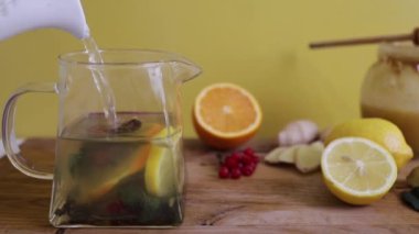 Tahta masada limon ve bal eşliğinde sağlıklı zencefil çayı yapmak.
