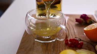 Tahta masada limon ve bal eşliğinde sağlıklı zencefil çayı yapmak.