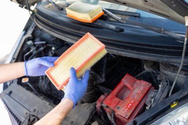 Arabanın hava filtresini yenisiyle değiştiren tamirci, tanıdan sonra yeni bir filtre değiştirdi