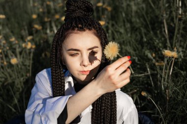 Bahar çiçeklerinin açtığı çayırda uzanan rahatlatıcı kadın. Kız yaz parkında dinleniyor. Hayatın tadını çıkar, eğlen, rahatla, rahatla, ilkbahar, yaşam tarzı konsepti