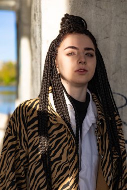 Leopar gömlekli genç bir kız terk edilmiş köprünün altında tek başına takılıyor, yaşam tarzı insan kavramı.