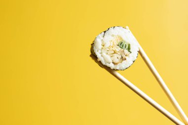 Somonlu suşi, karides ve sarı arka planda avokado..