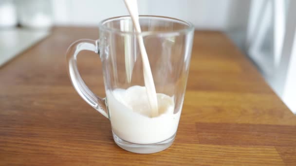 ガラスカップに牛乳を閉じます ヨーグルトとガラス 乳製品の概念 朝は乳糖を含まない生乳を飲む — ストック動画