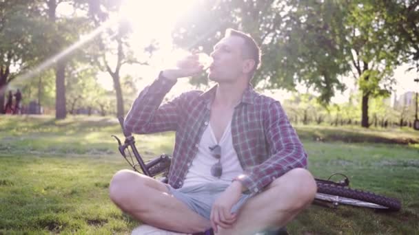Een Jonge Motorrijder Rust Een Groene Weide Hij Drinkt Water — Stockvideo