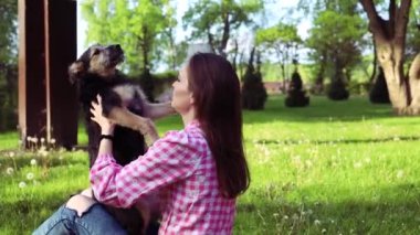 Parkta genç köpeğiyle oynayan güzel bir genç kadın. Yaşam tarzı portresi.