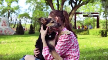 Parkta genç köpeğiyle oynayan güzel bir genç kadın. Yaşam tarzı portresi.
